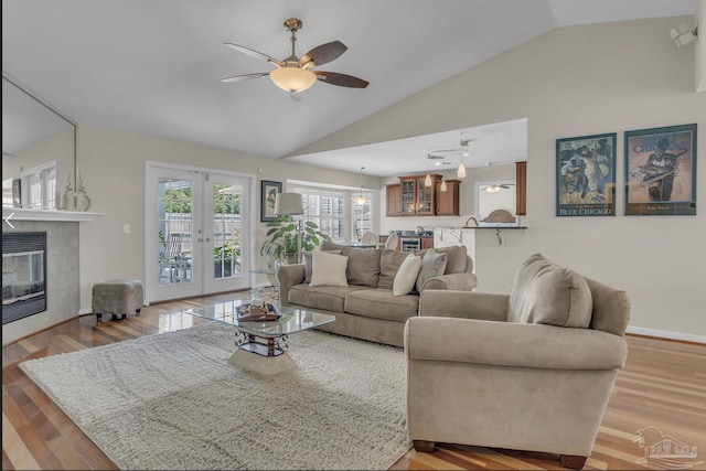1707 Cedrus Ln, Pensacola, FL 32514 - living room with vaulted ceiling, a ceiling fan, wood finished floors, a tile fireplace, and french doors
