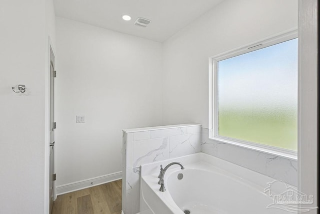 605 Ard Field Rd, Jay, FL 32565 - bathroom with a garden tub, wood finished floors, and baseboards