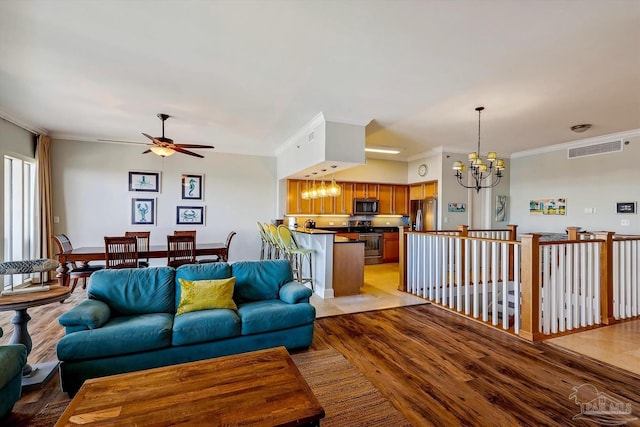 living room featuring ornamental molding, ceiling fan with notable chandelier, and light hardwood / wood-style flooring