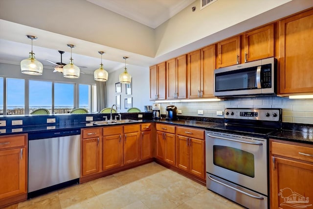 kitchen featuring stainless steel appliances, sink, backsplash, and decorative light fixtures