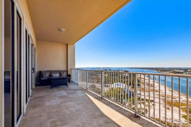 balcony with a water view and a view of the beach