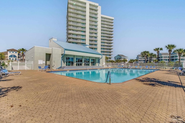 pool with a patio area and fence