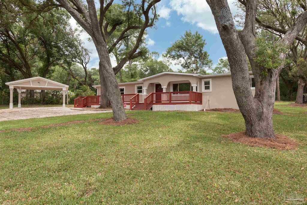 view of front of home with a front lawn, stucco siding, driveway, and a carport