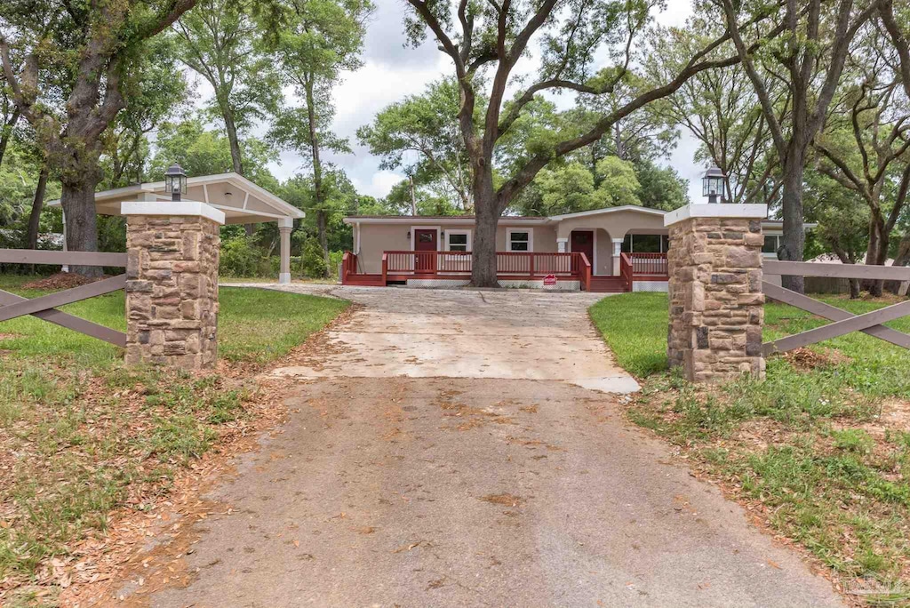 single story home with a porch, fence, and concrete driveway