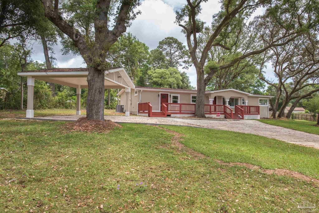 view of front of property featuring driveway, a front yard, a wooden deck, a carport, and central air condition unit