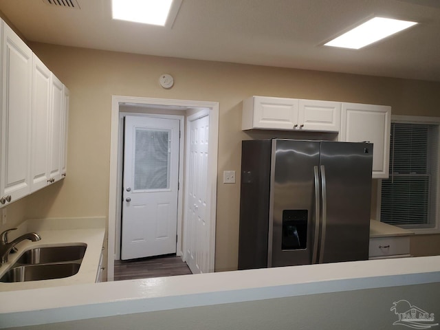 kitchen featuring stainless steel fridge with ice dispenser, white cabinetry, dark wood-type flooring, and sink