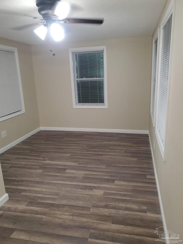 empty room with a textured ceiling, ceiling fan, and dark wood-type flooring