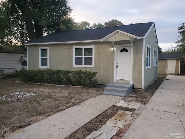 view of front of property featuring a shed