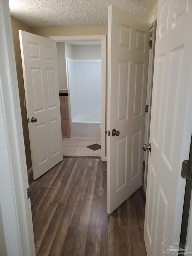 corridor featuring dark hardwood / wood-style floors and a textured ceiling