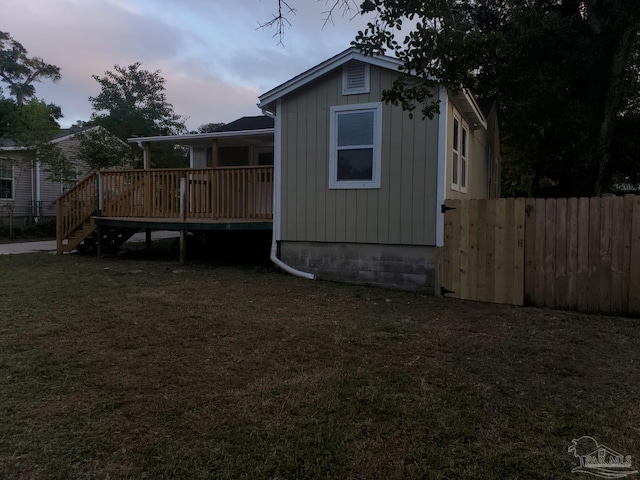 property exterior at dusk featuring a deck