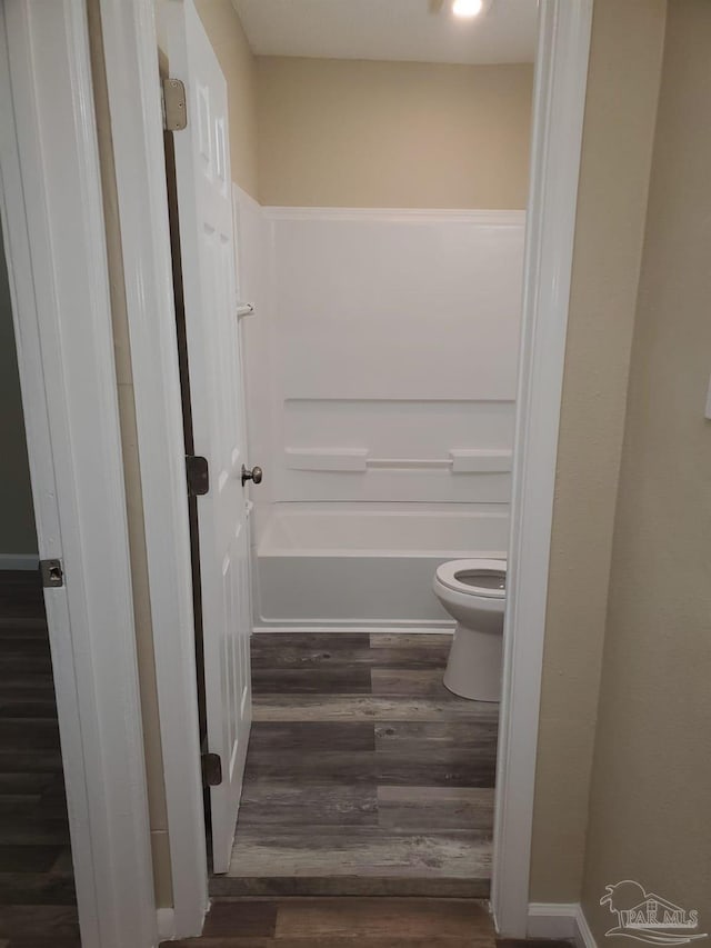 bathroom featuring hardwood / wood-style floors, shower / bath combination, and toilet