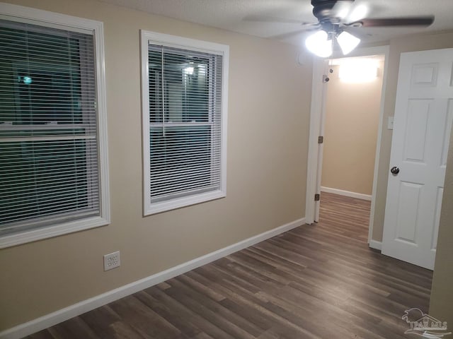 spare room featuring ceiling fan, dark wood-type flooring, and a textured ceiling