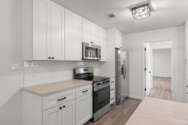 5547 Kauffman Rd, Milton, FL 32583 - kitchen with stainless steel appliances, wood finished floors, light countertops, backsplash, and white cabinets