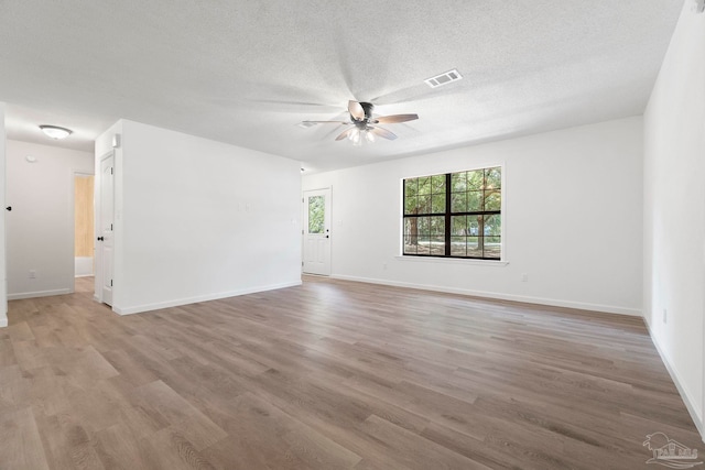 5547 Kauffman Rd, Milton, FL 32583 - empty room featuring a ceiling fan, light wood-style flooring, baseboards, and a textured ceiling