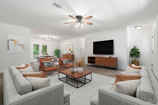 5547 Kauffman Rd, Milton, FL 32583 - living area with light wood-style flooring, a ceiling fan, baseboards, and a textured ceiling