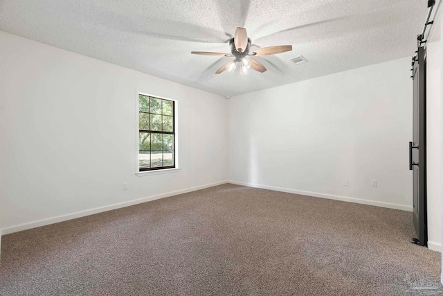 5547 Kauffman Rd, Milton, FL 32583 - unfurnished room with a ceiling fan, carpet flooring, a textured ceiling, a barn door, and baseboards