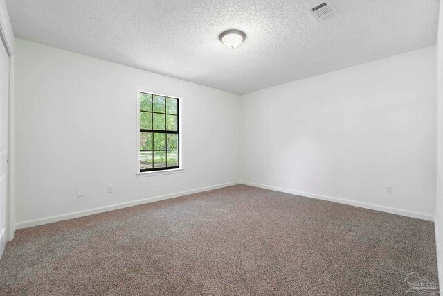 5547 Kauffman Rd, Milton, FL 32583 - empty room featuring a textured ceiling, carpet floors, and baseboards