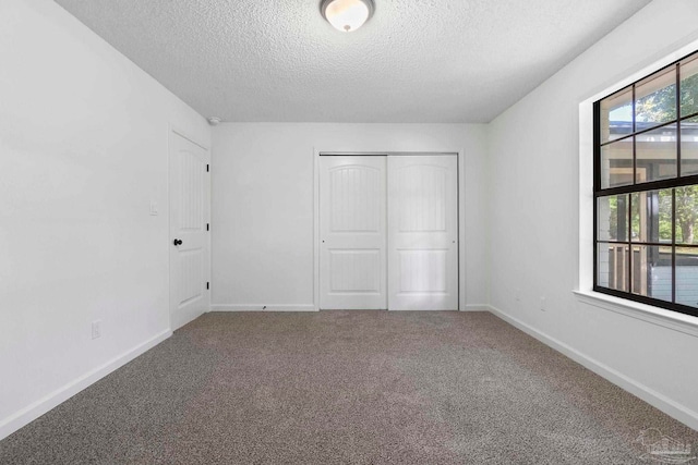 5547 Kauffman Rd, Milton, FL 32583 - unfurnished bedroom featuring a textured ceiling, carpet, a closet, and baseboards