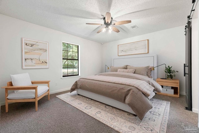 5547 Kauffman Rd, Milton, FL 32583 - bedroom featuring carpet floors, a textured ceiling, baseboards, ceiling fan, and a barn door