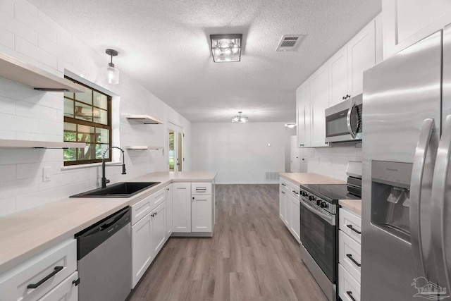 5547 Kauffman Rd, Milton, FL 32583 - kitchen with stainless steel appliances, open shelves, a sink, decorative backsplash, and white cabinetry