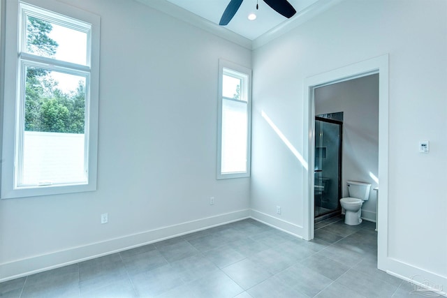 unfurnished bedroom with light tile patterned flooring, ensuite bath, multiple windows, and ceiling fan