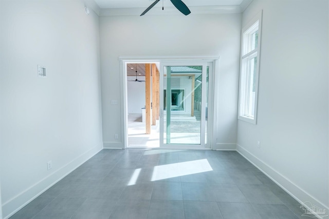 tiled spare room featuring ceiling fan