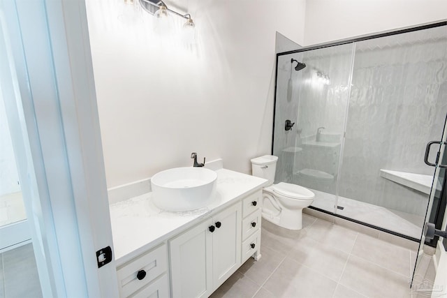 bathroom featuring a shower with shower door, vanity, tile patterned flooring, and toilet