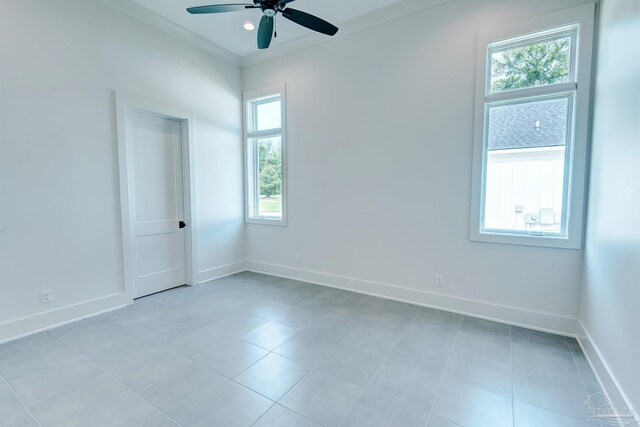 tiled empty room featuring ceiling fan and plenty of natural light