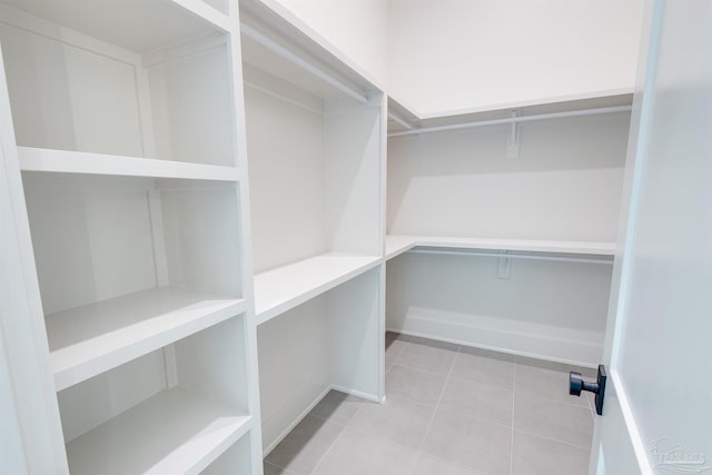 walk in closet with light tile patterned floors