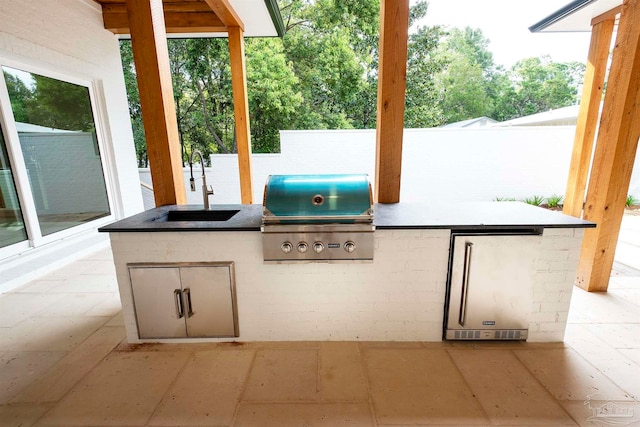 view of patio / terrace featuring area for grilling, sink, and a grill