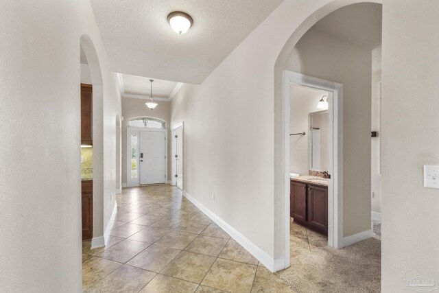 carpeted living room featuring a textured ceiling, a raised ceiling, ornamental molding, and ceiling fan