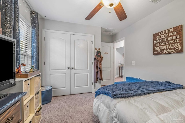 carpeted bedroom with ceiling fan and a closet