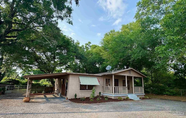 6414 Hamilton Bridge Rd, Milton, FL 32570 - view of front of home featuring a porch, concrete block siding, an attached carport, and gravel driveway