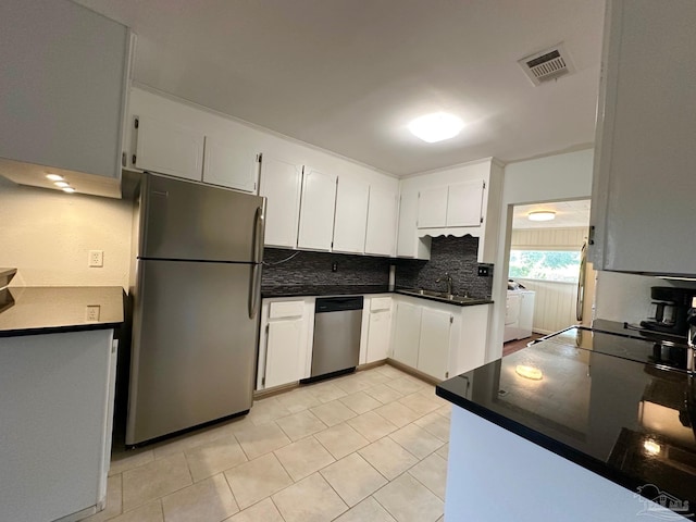 6414 Hamilton Bridge Rd, Milton, FL 32570 - kitchen with appliances with stainless steel finishes, washing machine and clothes dryer, dark countertops, tasteful backsplash, and light tile patterned flooring