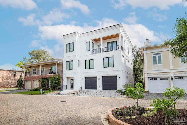 view of front of property featuring a balcony and a garage