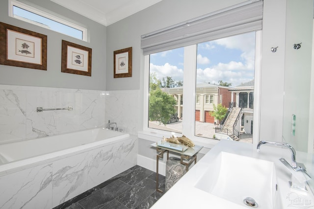 bathroom featuring tiled bath, plenty of natural light, sink, and crown molding