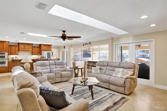 living room with light tile patterned flooring, recessed lighting, a skylight, visible vents, and french doors