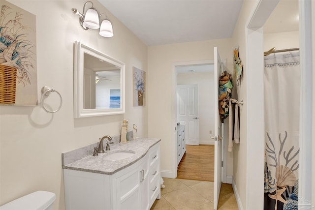 full bathroom with a shower with shower curtain, toilet, vanity, baseboards, and tile patterned floors