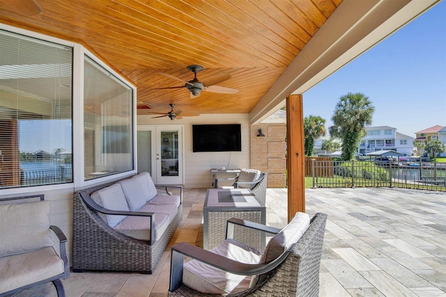 view of patio / terrace with fence, an outdoor living space, and a ceiling fan