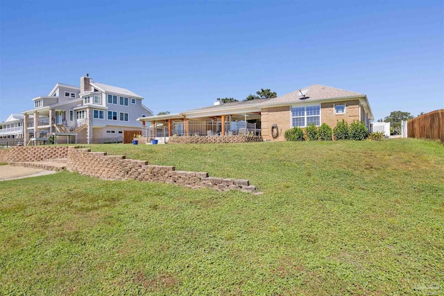 back of property featuring a yard and fence