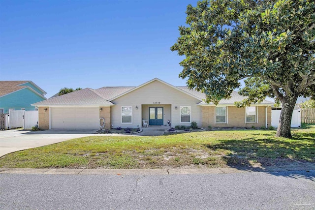 single story home with concrete driveway, an attached garage, fence, french doors, and a front lawn