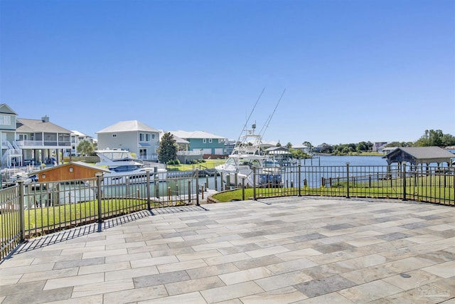 view of patio / terrace featuring a water view, fence, and a residential view