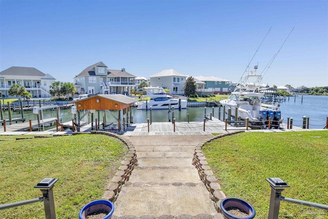 view of dock with a yard, a water view, boat lift, and a residential view