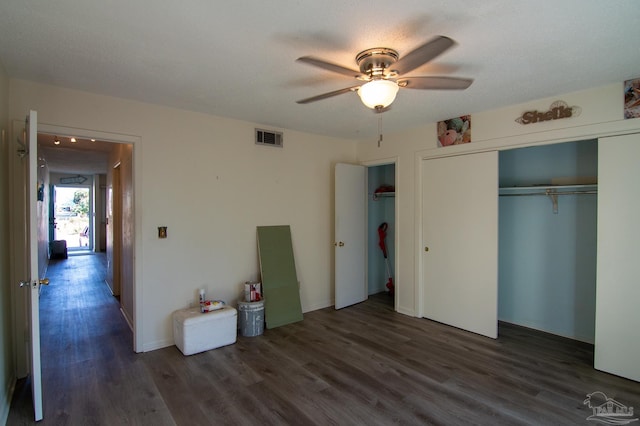 unfurnished bedroom with a textured ceiling, ceiling fan, a closet, and dark hardwood / wood-style floors