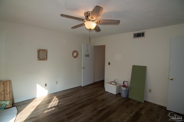 unfurnished room featuring ceiling fan, dark hardwood / wood-style flooring, and a textured ceiling