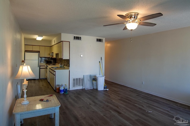 kitchen featuring backsplash, sink, dark wood-type flooring, and white refrigerator