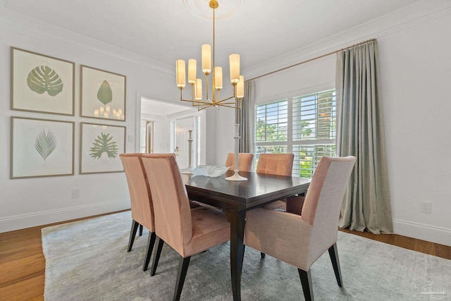 dining space featuring crown molding, hardwood / wood-style flooring, and a notable chandelier