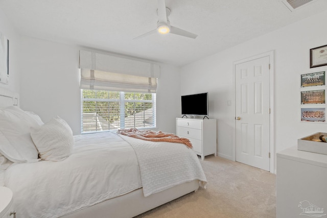 bedroom with light carpet, a textured ceiling, and ceiling fan