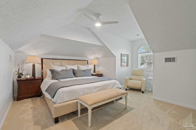 bedroom with lofted ceiling, a textured ceiling, light colored carpet, and ceiling fan