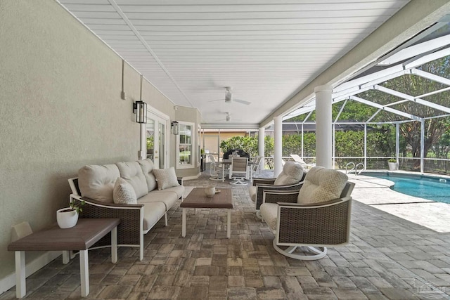 view of patio / terrace featuring an outdoor hangout area, glass enclosure, and ceiling fan